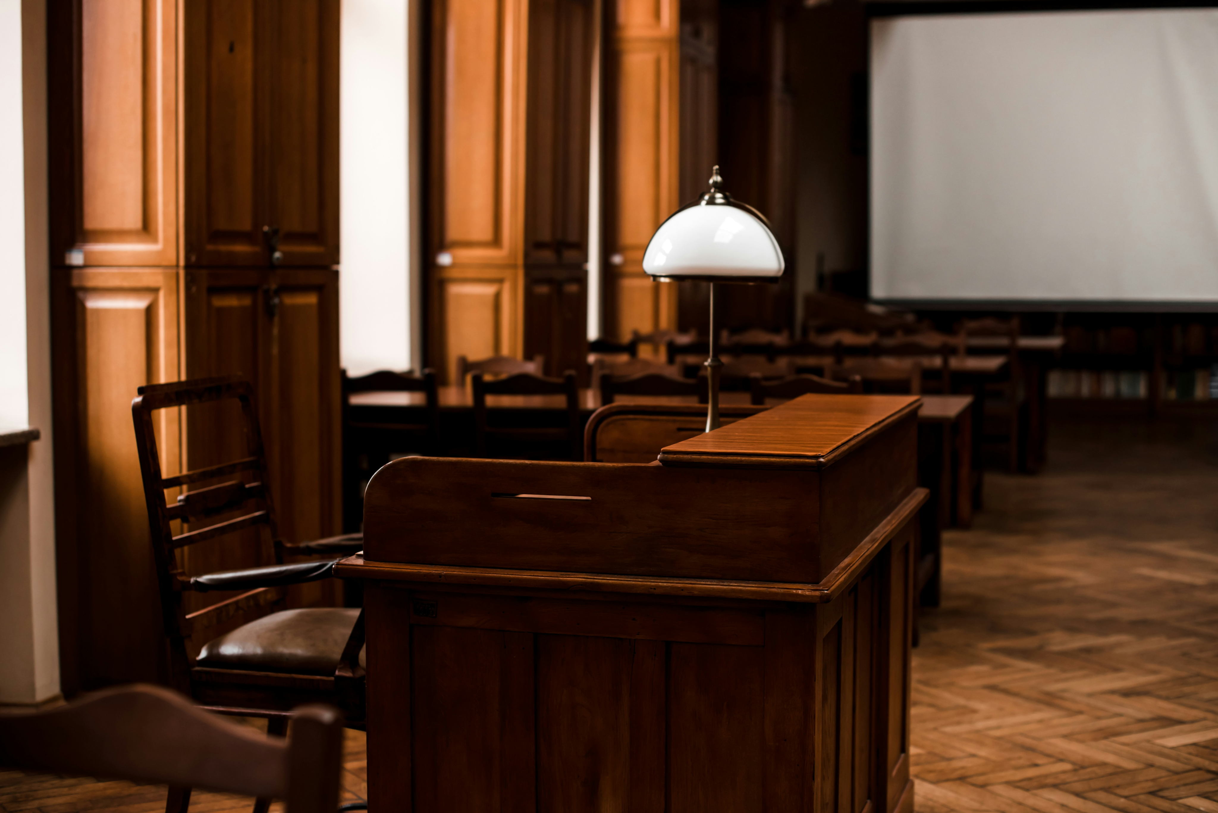 Photo of a wooden lectern and chair inside a room.